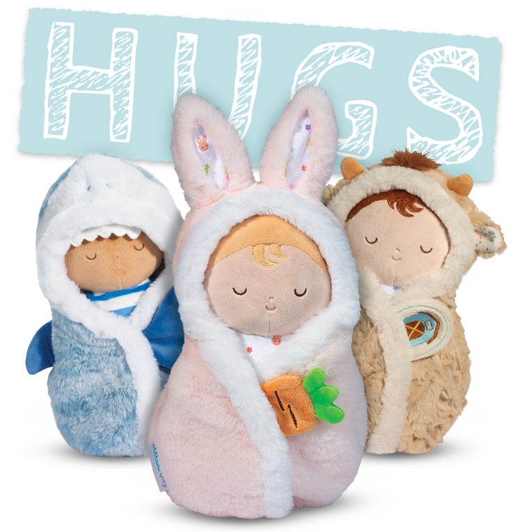 Three soft plush baby dolls from the Douglas Hugs collection, featuring a blue shark, pink bunny, and tan swaddle design.